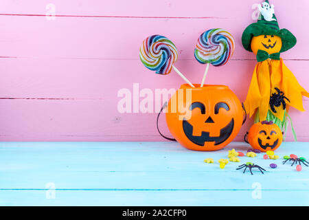 Trick or Treat - halloween jack o' lanterna, candy e rainbow lollipop in rosa e blu sullo sfondo di legno con copia spazio per il testo. Piatto, laici vista superiore Foto Stock