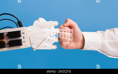 Il robot e la mano umana rendendo pugno gesto bump Foto Stock