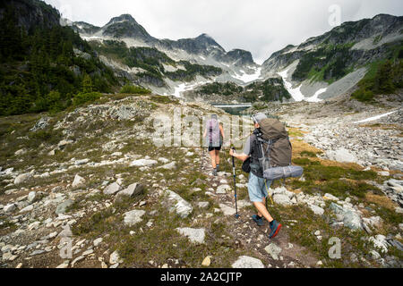 Un paio di escursioni a piedi lungo un sentiero per una notte di campeggio in montagna. Foto Stock