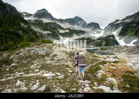 Un paio di escursioni a piedi lungo un sentiero per una notte di campeggio in montagna. Foto Stock