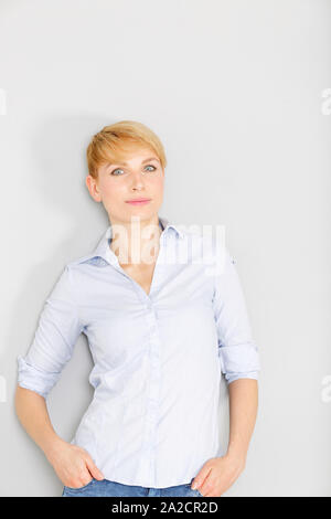 Attraente giovane donna in un blu Camicia casual rilassante in un fashion style pongono Foto Stock