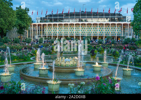 I Giardini di Tivoli Concert Hall e fontane illuminate di notte a Copenhagen, in Danimarca. Foto Stock