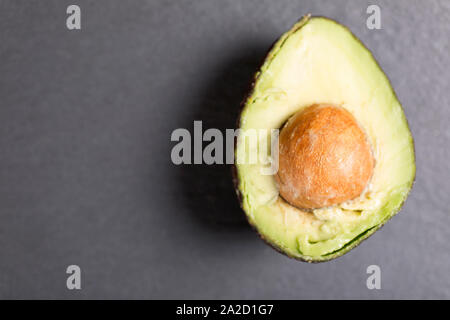 Esotici avocado fresco su nero ardesia con spazio di copia Foto Stock