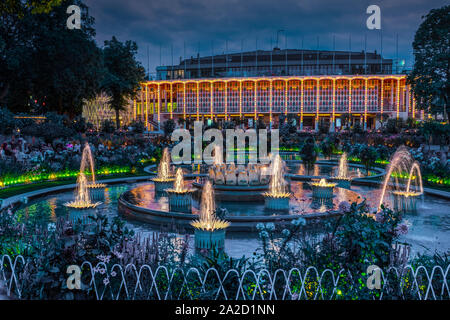 I Giardini di Tivoli Concert Hall e fontane illuminate di notte a Copenhagen, in Danimarca. Foto Stock