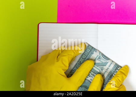 Punto coperta da un guanto dito ad un magazzino vuoto pagina. Rosa luminoso e sfondo giallo. Foto Stock