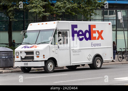 Il furgone FedEx Express è parcheggiato sul lato della strada in una città. Foto Stock