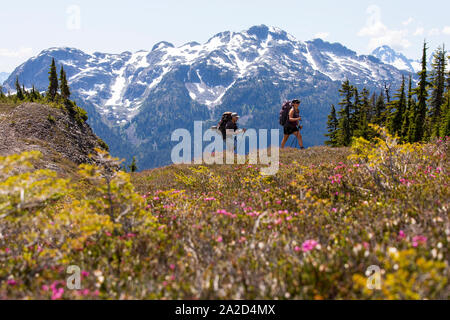 Un paio di escursioni a piedi lungo un sentiero per una notte di campeggio in montagna. Foto Stock