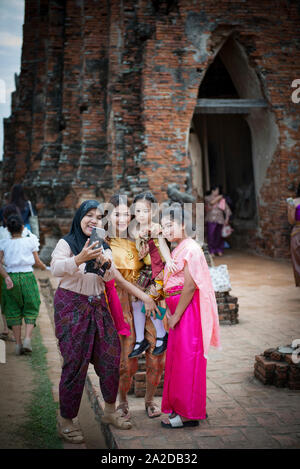 Le donne che prendono un selfie con un tradizionale costume tailandese durante il Ayutt Foto Stock