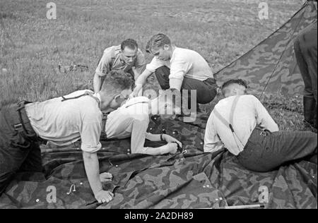 Rekruten der Luftwaffe der Wehrmacht bauen im Rahmen der militärischen Grundausbildung ein Zelt auf, Deutschland 1930er Jahre. Reclute della Luftwaffe tedesca portando una tenda nella loro formazione militare, Germania 1930s. Foto Stock