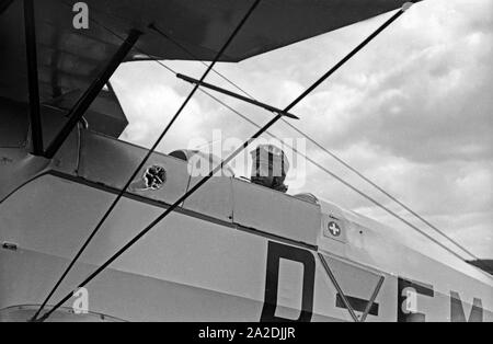 Am Steuer des Ausbildungsflugzeugs Bücker Bü 131 Jungmann, Deutschland 1930er Jahre. Nella cabina di pilotaggio del piano di formazione Buecker Bue 131 Jungmann al Flieger Ausbildungsstelle Schoenwalde, Germania 1930s. Foto Stock