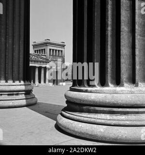 Blick zwischen Säulen hindurch auf die Propyläen am Königsplatz in München, Deutscnland 1930er Jahre. Vista tra le colonne per l'edificio Propylaeen Koenigsplatz a piazza della città di Monaco di Baviera, Germania 1930s. Foto Stock