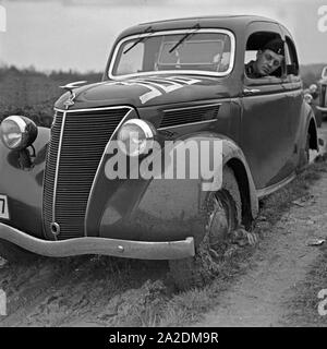 Ein Ford Eifel steckt bei einer Autorallye im Schlamm fest, Deutschland 1930er Jahre. Un modello Ford Eifel inceppato nel fango ad un auto rallye, Germania 1930s. Foto Stock