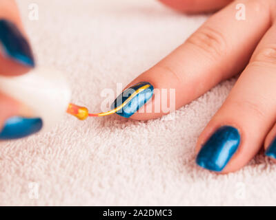 Pittura moderna Nail art con oro Nail Polish a base blu Foto Stock