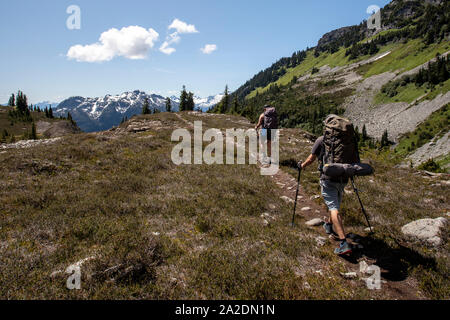 Un paio di escursioni a piedi lungo un sentiero per una notte di campeggio in montagna. Foto Stock