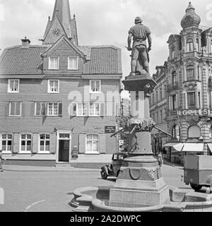 Blick auf die Gaststätte "Im Jägerhof' von Carl Schaaf und das Denkmal des tapferen Schmieds Peter Hahn auf dem Alten Markt in Solingen, Deutschland, 1930er Jahre. Vista del ristorante Jaegerhof e il monumento di brave fabbro Peter Hahn presso il vecchio mercato principale di Solingen, Germania 1930s. Foto Stock