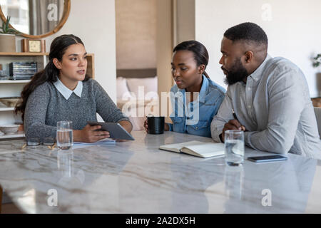 Advisor finanziario di parlare con un americano africano giovane a casa Foto Stock