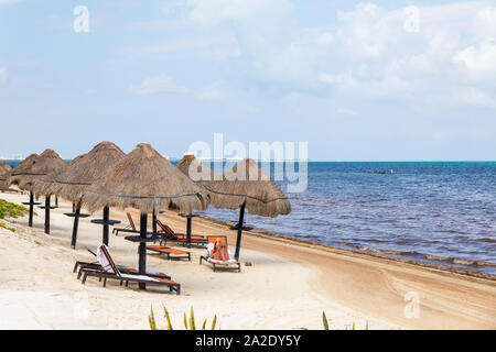 Cancun, Messico - 30 Ago, 2019 : il Mare dei Caraibi con sedie a sdraio e ombrelloni in erba nella parte anteriore del Moon Palace Resorts, Cancun, Messico Foto Stock