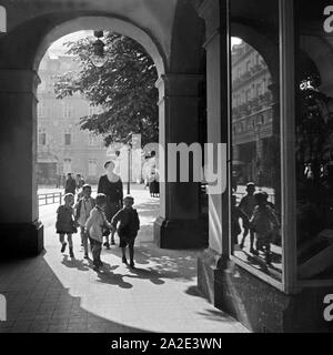 Eine Kindergärtnerin ist mit ihrer Kindergruppe unterwegs in der Innenstadt von Bad Ems, Deutschland 1930er Jahre. Un insegnante kinergarten passeggiando con il suo gruppo di bambini attraverso la parte interna della città di Bad Ems, Germania 1930s. Foto Stock