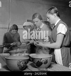 Frauen schälen Pellkartoffeln beim weiblichen Arbeitsdienst in Molkenberg bei Fürstenwalde, Deutschland 1930er Jahre. Le donne la pelatura di patate nella pelle per la forza lavoro femminile gruppo di Molkenberg, Germania 1930s. Foto Stock