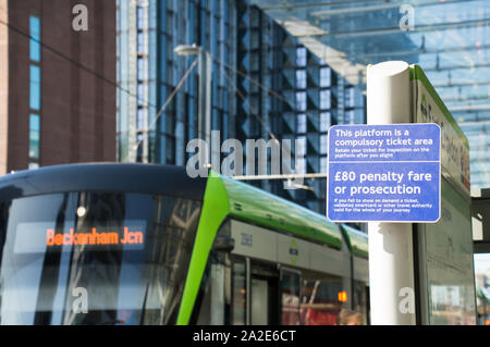 Tariffa di penalizzazione segno di avvertimento a TFL azionato il tram della piattaforma con il tram sullo sfondo Foto Stock