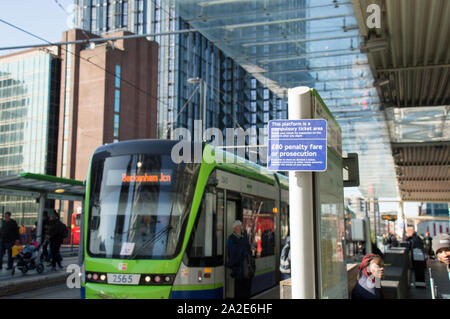 Tariffa di penalizzazione segno di avvertimento a TFL azionato il tram della piattaforma con il tram sullo sfondo Foto Stock