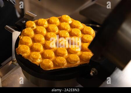 Rendendo cialde on dark waffle ferro, scatti Foto Stock