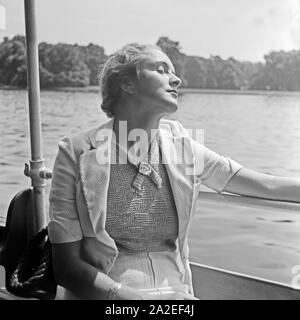 Eine junge Frau beim Sonnenbad auf einem Auslugsdampfer auf der Spree a Berlino, Deutschland 1930er Jahre. Una giovane donna a prendere il sole su una barca di divertimento al fiume Sprea a Berlino, Germania 1930s. Foto Stock