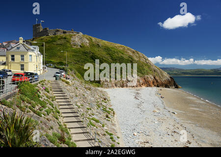 Guardando lungo la passeggiata e il mare verso Criccieth Castle durante l'estate. Foto Stock