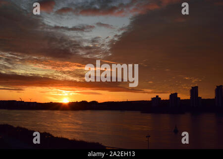 Alba sul Fiume Tamigi su una tempesta giornata autunnale Foto Stock