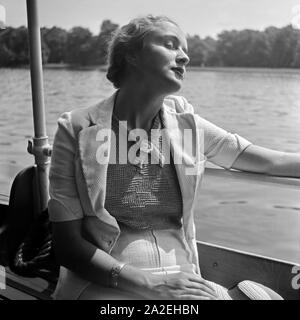 Eine junge Frau beim Sonnenbad auf einem Auslugsdampfer auf der Spree a Berlino, Deutschland 1930er Jahre. Una giovane donna a prendere il sole su una barca di divertimento al fiume Sprea a Berlino, Germania 1930s. Foto Stock