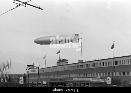 Zeppelin Hindenburg LZ 129 bei der Olympiafahrt über dem Flughafen Berlin Tempelhof, Deutschland 1930er Jahre. Zeppeilin Hindenburg LZ 129 in corrispondenza della sua corsa olimpica oltre l'aeroporto Tempelhof a Berlino, Germania 1930s. Foto Stock