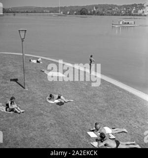 Badende und Sonnenanbeter sono Max Eyth vedere a Stuttgart, Deutschland 1930er Jahre. Lucertole da mare sulla spiaggia di Max Eyth lago a Stuttgart, Germania 1930s. Foto Stock