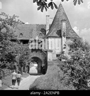 Ein Mann und eine Frau wandern zur alten Burganlage a Burghausen, Deutschland 1930er Jahre. Un uomo e una donna vagare per il vecchio castello di Burghausen, Germania 1930s. Foto Stock