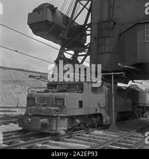 Ein Güterzug, von einer Elektrolokomotive gezogen, wird mit einer Ladung Bernstein bei Palmnicken im Samland in Ostpreußen befüllt, Deutschland 1930er Jahre. Un treno merci è caricato con ambra a Palmnicken in Zambia nella Prussia orientale, Germania 1930 Foto Stock