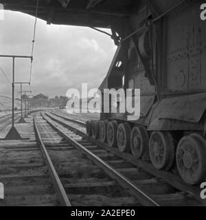 Ein Güterzug, von einer Elektrolokomotive gezogen, wird mit einer Ladung Bernstein bei Palmnicken im Samland in Ostpreußen befüllt, Deutschland 1930er Jahre. Un treno merci è caricato con ambra a Palmnicken in Zambia nella Prussia orientale, Germania 1930 Foto Stock