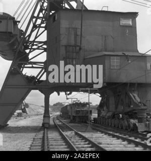 Ein Güterzug, von einer Elektrolokomotive gezogen, wird mit einer Ladung Bernstein bei Palmnicken im Samland in Ostpreußen befüllt, Deutschland 1930er Jahre. Un treno merci è caricato con ambra a Palmnicken in Zambia nella Prussia orientale, Germania 1930 Foto Stock