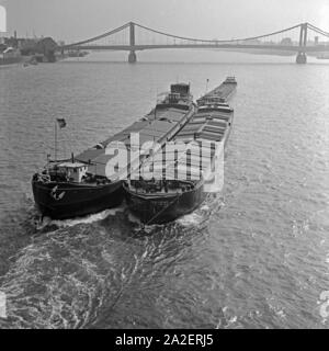 Ein Raab Karcher Schlepperverband hat auf dem Rhein in Köln die Hindenburgbrücke passiert, Deutschland 1930er Jahre. Tre towboats superato il ponte Hindenburgbruecke nel fiume Reno a Colonia, Germania 1930s. Foto Stock