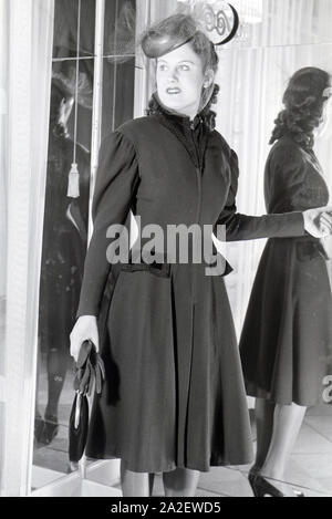 Ein modello bei der Anprobe eines Kleides von Modeschöpferin Annemaria Geise; Deutschland ca. 1939. Un modello cercando un abito del designer di moda Annemaria Geise; Germania ca. 1939. Foto Stock