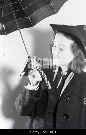 Ein Besucherin der Wiener Modewoche, im Haus der modo ' Palais Lobkowitz', bei einer Päsentation von Regenschirmen, Deutschland 1940er Jahre. Un visitatore della Vienna fashion week, nella casa di moda ' Palais Lobkowitz', a una presentazione di ombrelli, Germania 1940s. Foto Stock