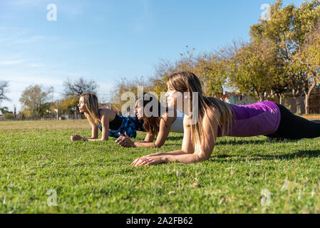 Tre giovani amici di sesso femminile che lavora fuori nel parco, all'esterno. Sport, Salute e stile di vita del concetto. Foto Stock