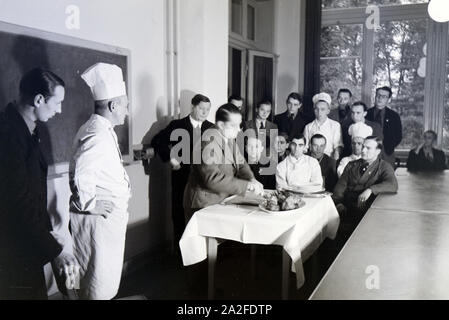 Bei einer Veranstaltung der Reichskochschule erklärt ein Meisterkoch den Lehrlingen das Richtige Filetieren, Deutschland 1930er Jahre. Un master chef è presentare il modo corretto di sfilettatura ai partecipanti nel corso di un seminario della Reichskochschule, Germania 1930s. Foto Stock