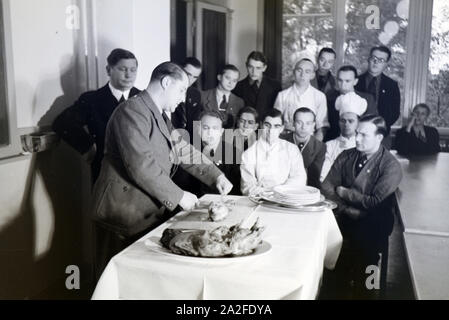 Bei einer Veranstaltung der Reichskochschule erklärt ein Meisterkoch den Lehrlingen das Richtige Filetieren, Deutschland 1930er Jahre. Un master chef è presentare il modo corretto di sfilettatura ai partecipanti nel corso di un seminario della Reichskochschule, Germania 1930s. Foto Stock