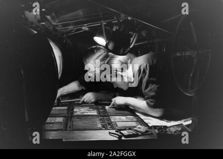 Zwei Drucker setzen letteran zu einem Schriftstatz un einer Rotationsdruckmaschine zusammen, Deutschland 1930er Jahre. Due stampanti sono disponendo di tipo metallico ordina rotative da stampa, Germania 1930s. Foto Stock