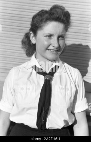 Porträt eines Mädchens BDM in uniforme mit der weißen Bluse, schwarzem Halstuch und Lederknoten, Deutschland 1930er Jahre. Ritratto di un uniforme della ragazza BDM indossando la camicia bianca, neckerchief nero e cuoio diapositiva, Germania 1930s. Foto Stock