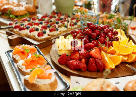 Frutti, bacche, spuntini di pesce e dessert sulla ristorazione ristorante tabella Foto Stock