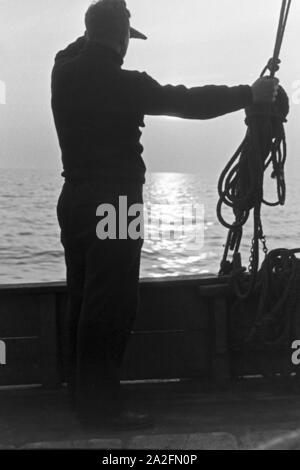 Ein Hochseefischer beobachtet die vedere, Deutschland 1930er Jahre. Deep sea fisherman controllo del mare, Germania 1930s. Foto Stock
