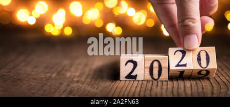 Mano che tiene i cubi di legno calendario con numero 2020, Felice anno nuovo 2020 concept. Foto Stock