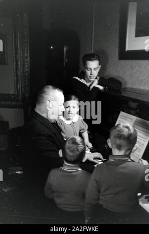 Mitglieder einer kinderreichen Familie beim Klavierspielen, Deutsches Reich 1930er Jahre. I membri di una famiglia estesa a suonare il pianoforte, Germania 1930s. Foto Stock