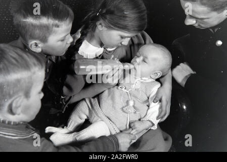 Mitglieder einer kinderreichen Familie mit dem Neugeborenen, Deutsches Reich 1930er Jahre. I membri di una famiglia estesa con il neonato, Germania 1930s. Foto Stock