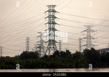 Massicce torri portando ad alta tensione e linee elettriche ad alta tensione nelle zone rurali del Vietnam Foto Stock